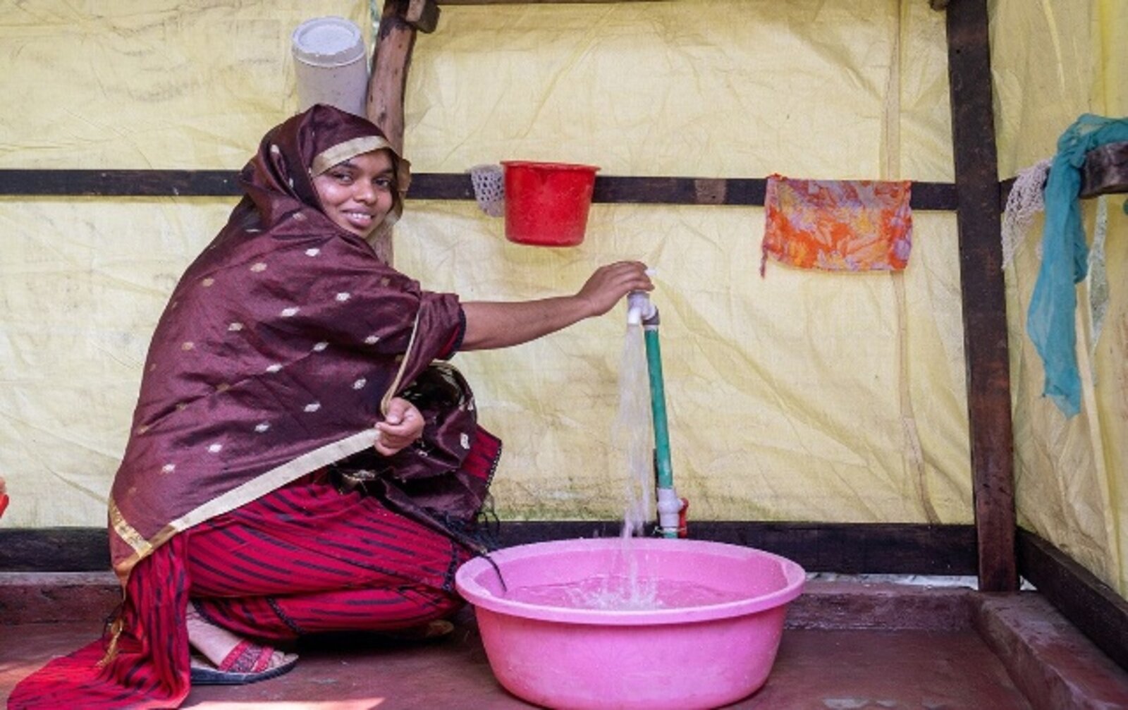 Hashi Akter at a community meeting learning about piped tap water